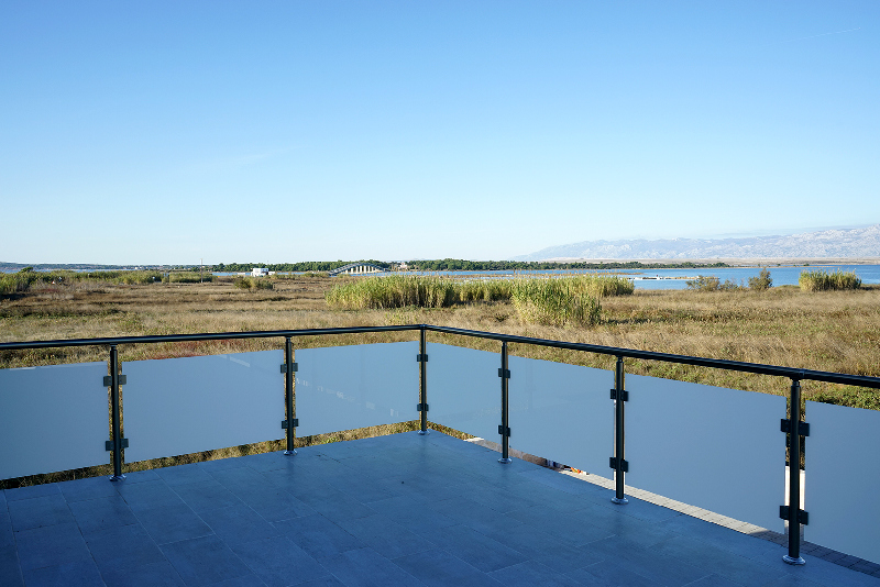 Terrazza con parapetto in vetro e vista sulle canne fino alla laguna