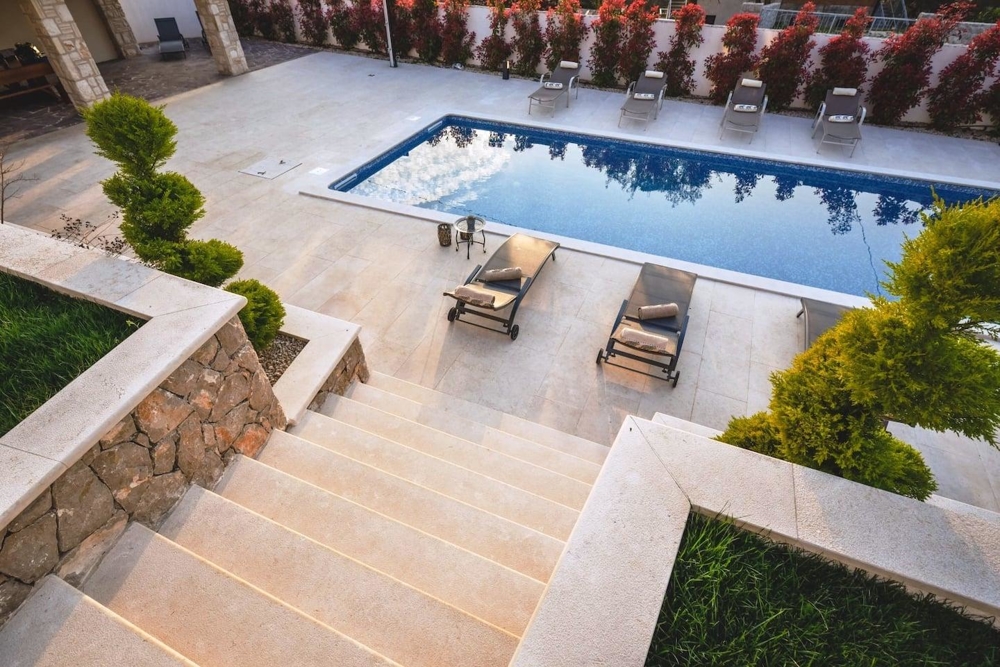 Vista sul giardino, sulla piscina e sul mare.
