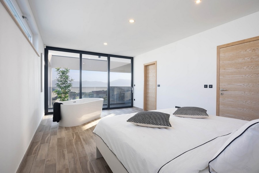 Luminosa camera da letto con vasca freestanding alla finestra