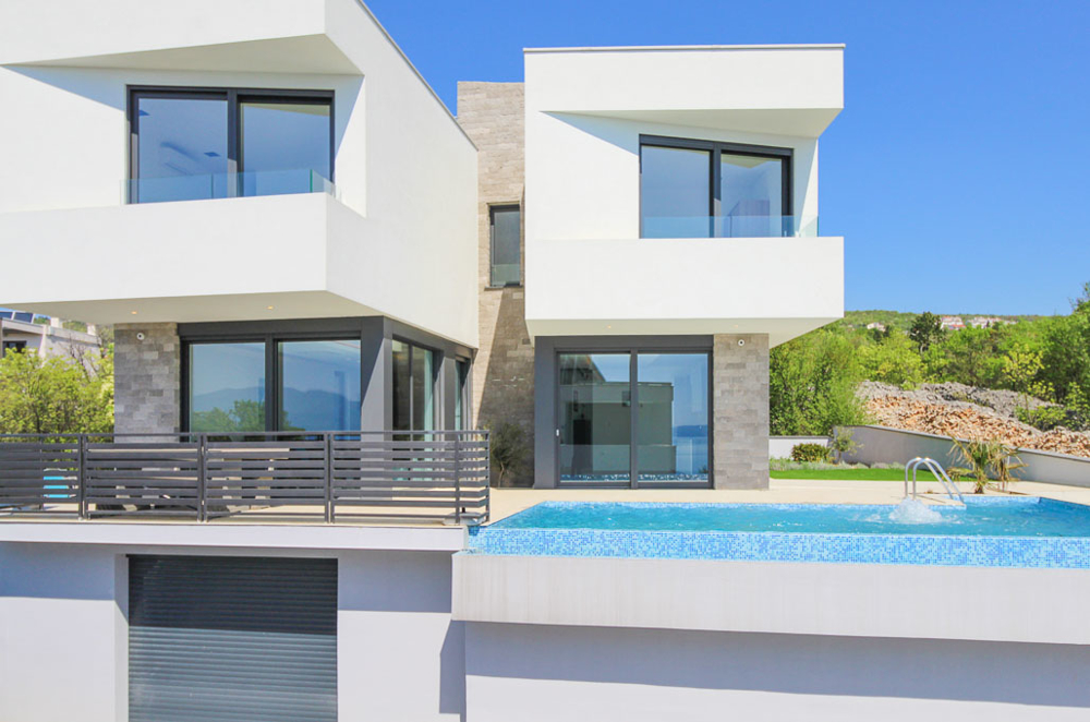 Villa bianca con fasce in pietra naturale e piscina in primo piano