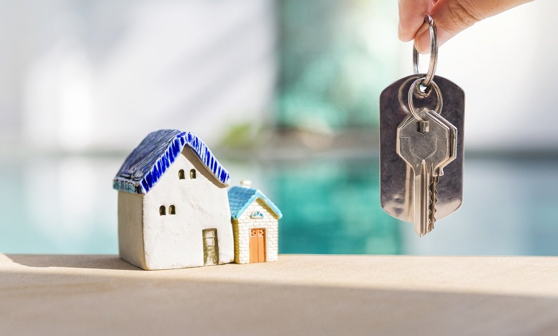 Consegna delle chiavi dopo l'acquisto di un immobile con modellino di casa